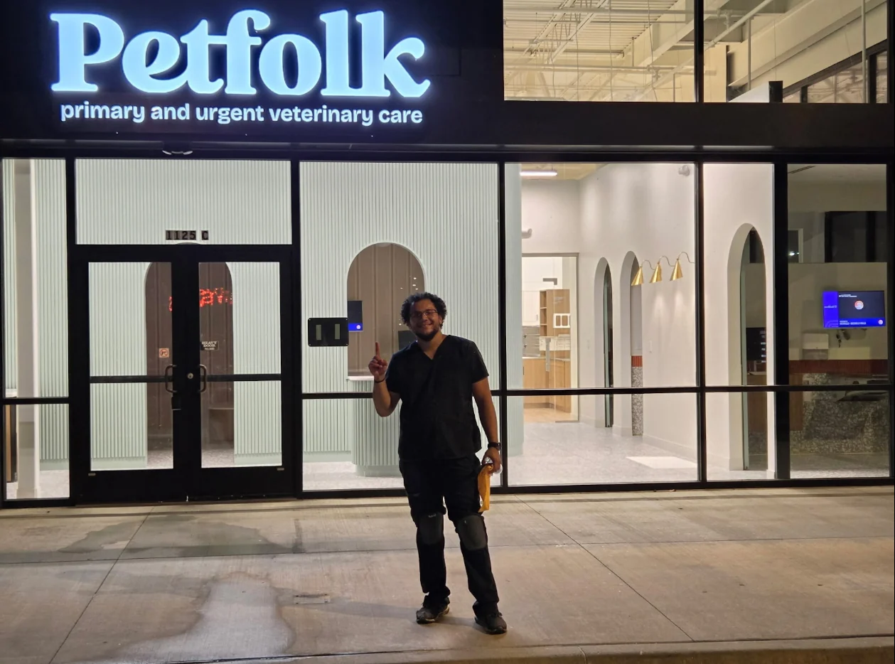 Julian outside a glass fronted veterinary clinic at a post construction cleaning project