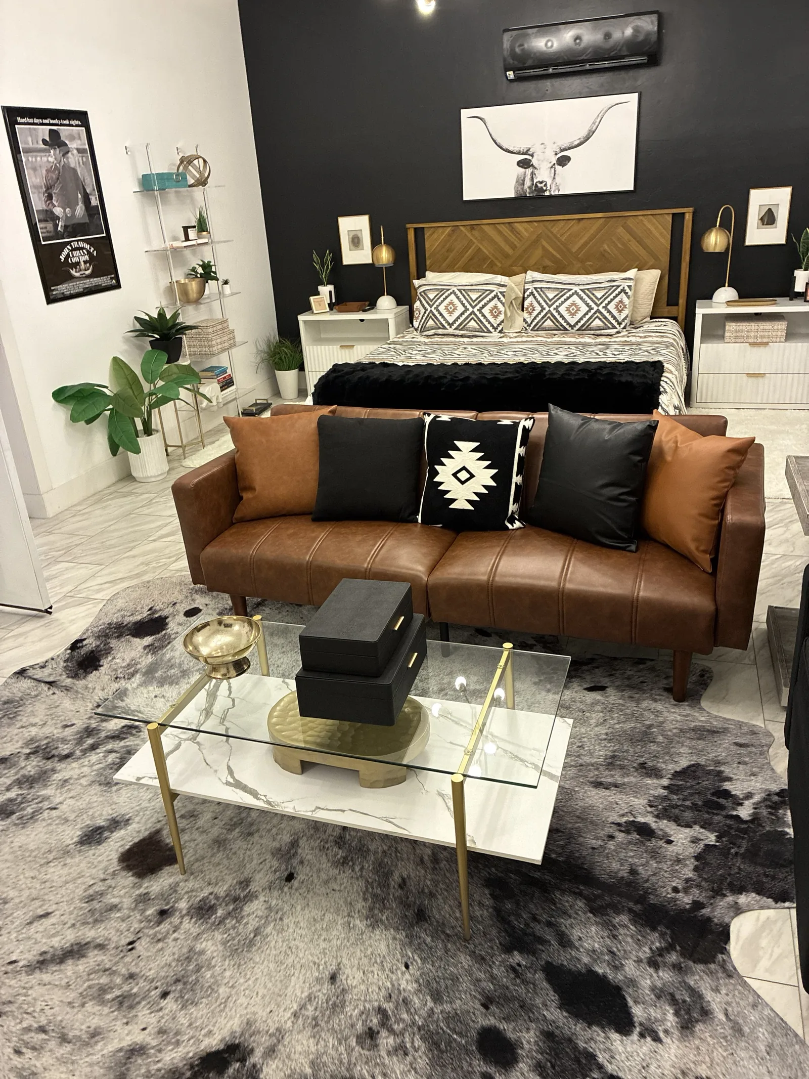Bedroom and sitting area with a brown leather sofa and a glass coffee table