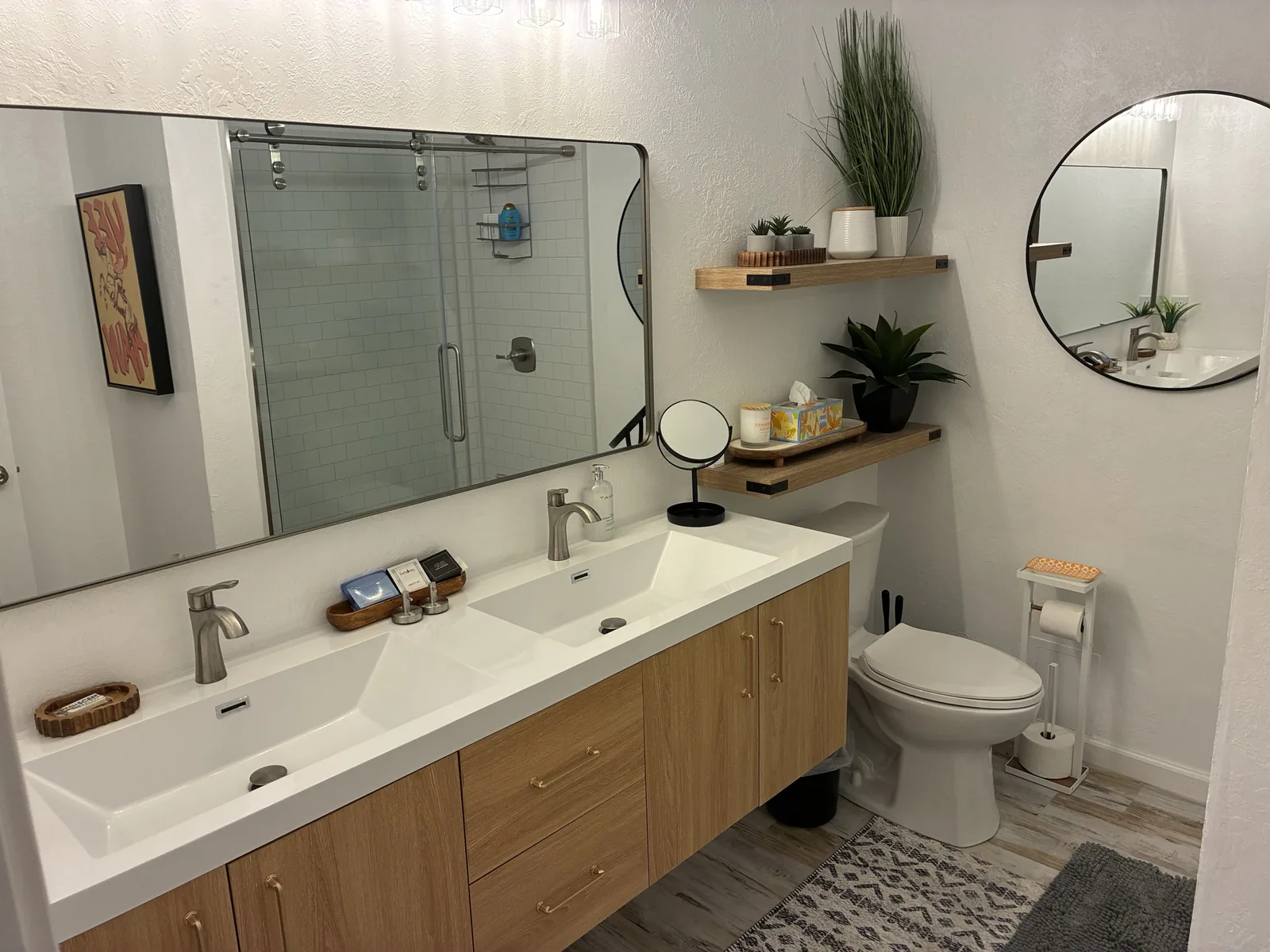 Bathroom with double sinks, oak vanity, mirrors and clear counters