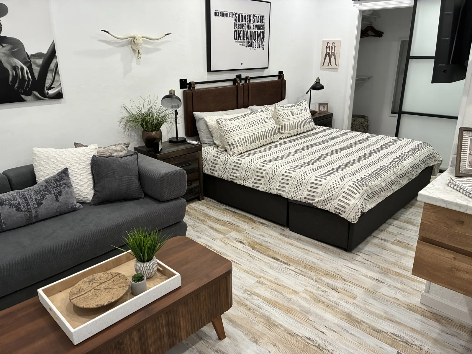 Furnished bedroom and sitting area with a neatly made bed and clear floors